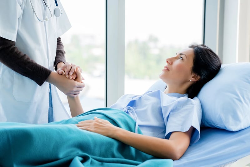 hospital staff holding patients hand with compassion